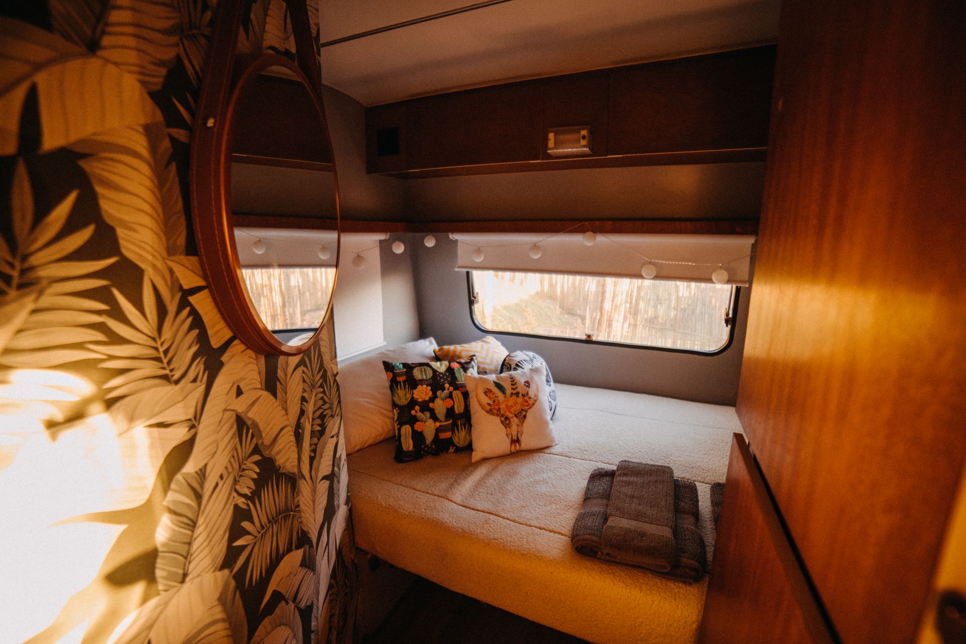 Renovated camper interior with styled bed and custom finishes