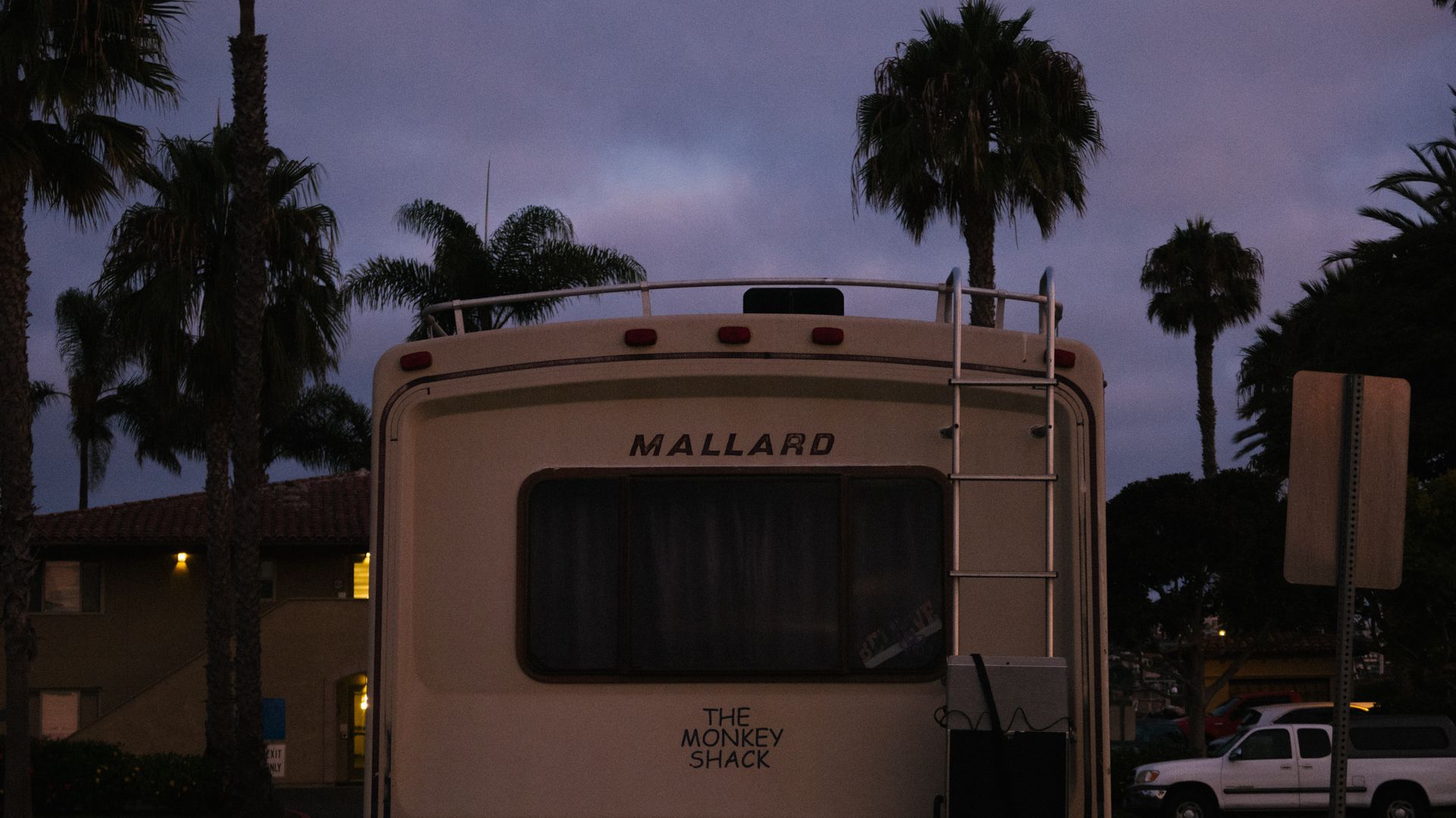 Restored retro RV under palm trees at dusk